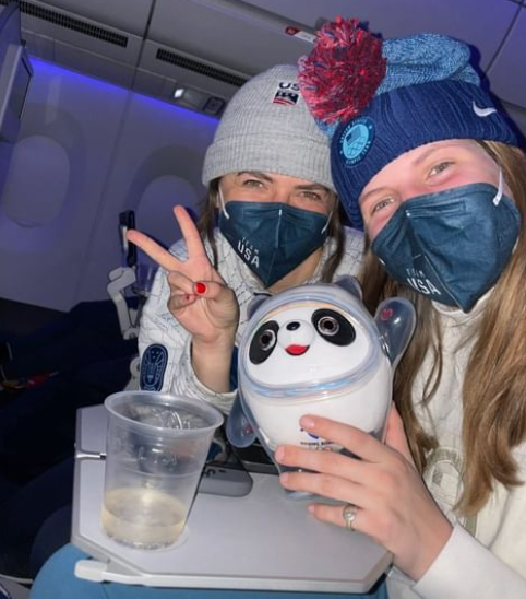  Schioara americană Hanna Faulhaber și o altă coechipieră sunt într-o fotografie cu Bing Dwen Dwen în avionul către acasă.