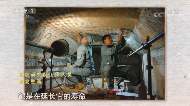Muncitorii restaurează picturi murale într-o peșteră.