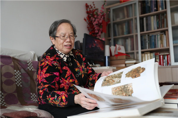 Η Λιου Γιμάν, που στο παρελθόν εργάστηκε ως αρχαιολόγος στην Κινεζική Ακαδημία Κοινωνικών Επιστημών, στην φωτογραφία με το βιβλίο που συνέταξε για τις αρχαιολογικές ανακαλύψεις των οστών μαντείας στην Κίνα. [Φωτογραφία: Chen Zebing / China Daily]