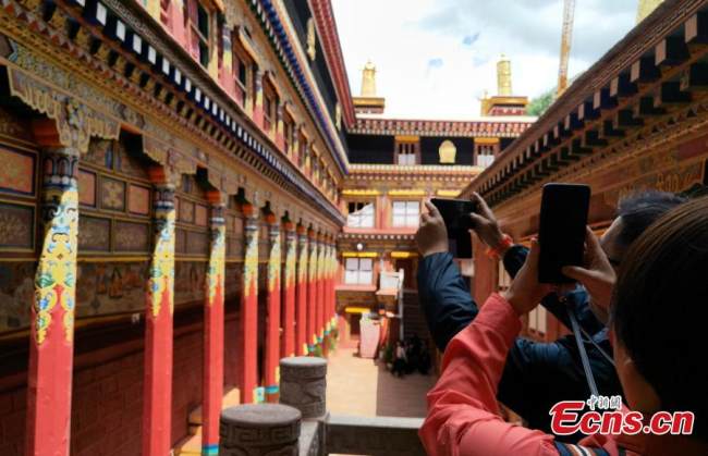 Επισκέπτες βγάζουν φωτογραφίες στο Τυπογραφείο Ντέργκε Σούτρα, στην κομητεία Ντέργκε, της αυτόνομης περιφέρειας των θιβετιανών Γκάρζε, στην επαρχία Σιτσουάν στις 20 Ιουλίου 2021