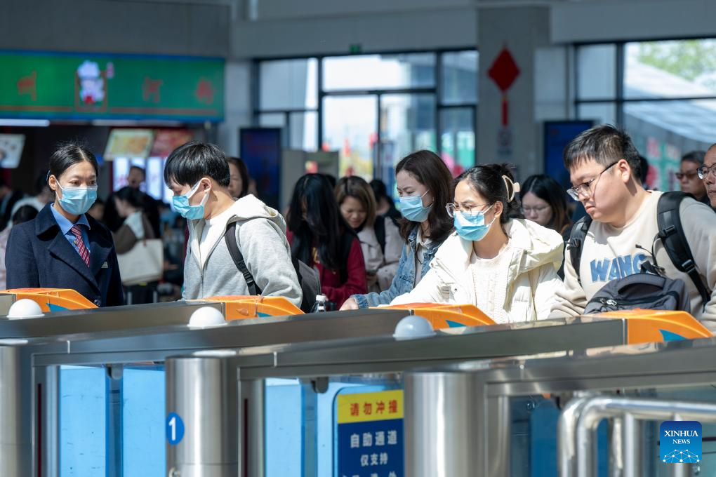 Ταξιδιώτες προετοιμάζονται να μπουν σε τρένο στο σταθμό του Γουτζόου, στην αυτόνομη περιοχή Γκουανγκσί Τζουάνγκ της νότιας Κίνας, 16 Φεβρουαρίου 2024. (Φωτογραφία He Huawen/Xinhua)