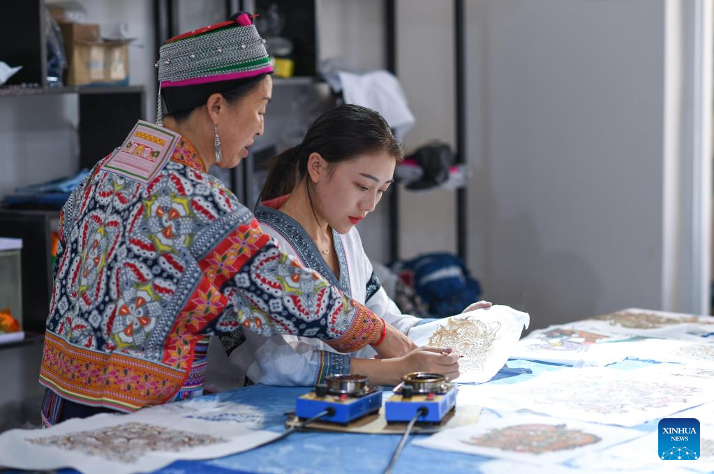 Η Τζουάν – Τζουάν  συζητά με την μητέρα της τις τεχνικές του μπατίκ στο Ανσούν της επαρχίας Γκουιτζόου της νοτιοδυτικής Κίνας, 18 Αυγούστου 2022.
