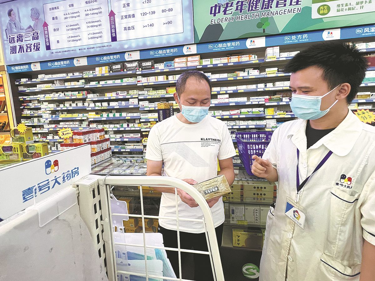 Një farmacist i liçensuar (djathtas) udhëzon një pacient në zgjedhjen e ilaçeve në një nga farmacitë në Guangzhou, provincën e Guangdong-ut, në nëntor
