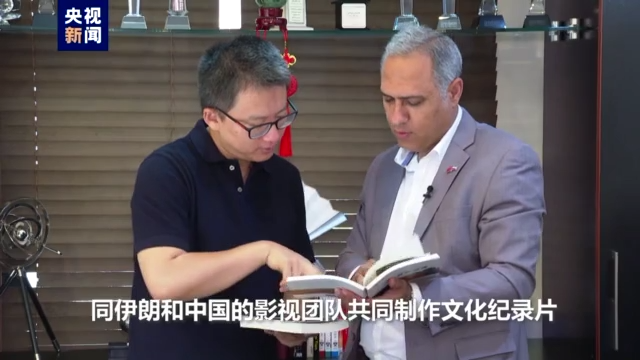 He Fei discută cu un regizor chinez despre proiectul de filmare a unui documentar.