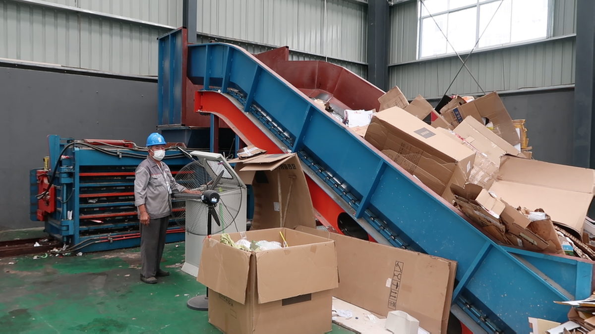 Një punonjës operon makina për të kompresuar fushë plastike dhe kartona në Qendrën e Transferimit të Riçiklueshëm të Pujinit në Shanghain e Kinës Lindore.