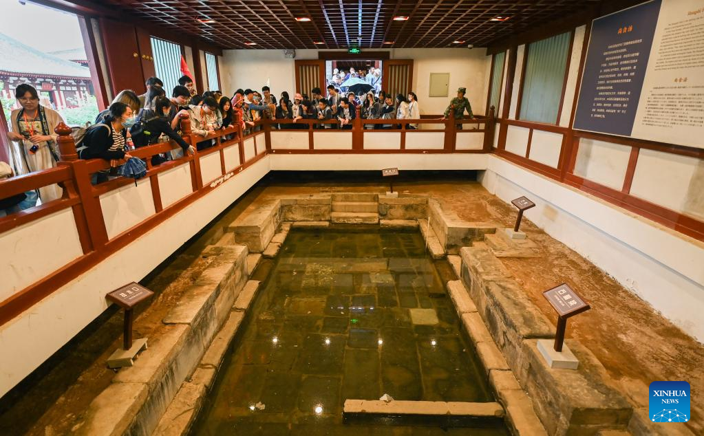 Οι τουρίστες επισκέπτονται ένα λείψανο μιας πισίνας στη γραφική περιοχή του Παλατιού Χουατσίνγκ στο Σι’αν, στην επαρχία Σαανσί της βορειοδυτικής Κίνας, στις 5 Μαΐου 2023. (Φωτογραφία Zou Jingyi/Xinhua)