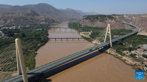 Αυτή η αεροφωτογραφία που τραβήχτηκε στις 9 Ιουλίου 2023 δείχνει μια γέφυρα πάνω από τον Κίτρινο Ποταμό στην αρχαία πόλη Χεκόου στο Λαντζόου, στην επαρχία Γκανσού της βορειοδυτικής Κίνας. [Xinhua / Zhang Keren]