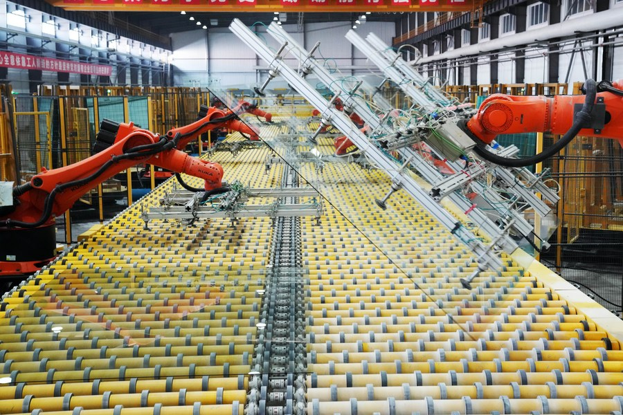 Αυτή η φωτογραφία που τραβήχτηκε στις 17 Φεβρουαρίου 2023 δείχνει βραχίονες ρομπότ να λειτουργούν σε μια γραμμή παραγωγής σε ένα εργοστάσιο γυαλιού στο Τζιαμουσί, στην επαρχία Χεϊλονγκτζιάνγκ της βορειοανατολικής Κίνας. (Xinhua/Wang Jianwei)