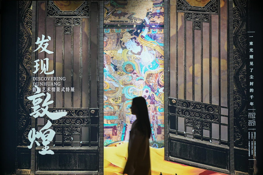 Επισκέπτης παρατηρεί εκθέματα σε μια έκθεση με θέμα τον πολιτισμό του Ντουνχουάνγκ στο Μουσείο Ψηφιακής Τέχνης στο Τιεντζίν στη βόρεια Κίνα, 28 Νοεμβρίου 2023. [Φωτογραφία/Xinhua]