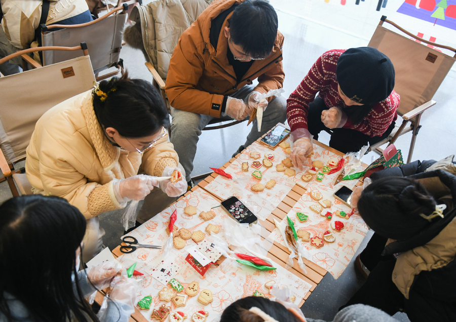 Οι μαθητές μαθαίνουν να φτιάχνουν μπισκότα κατά τη διάρκεια μιας βραδινής τάξης στην περιοχή της Ανατολικής Λίμνης του Γουχάν, στην επαρχία Χουμπέι της Κεντρικής Κίνας, 24 Δεκεμβρίου 2023. [Φωτογραφία/Xinhua]
