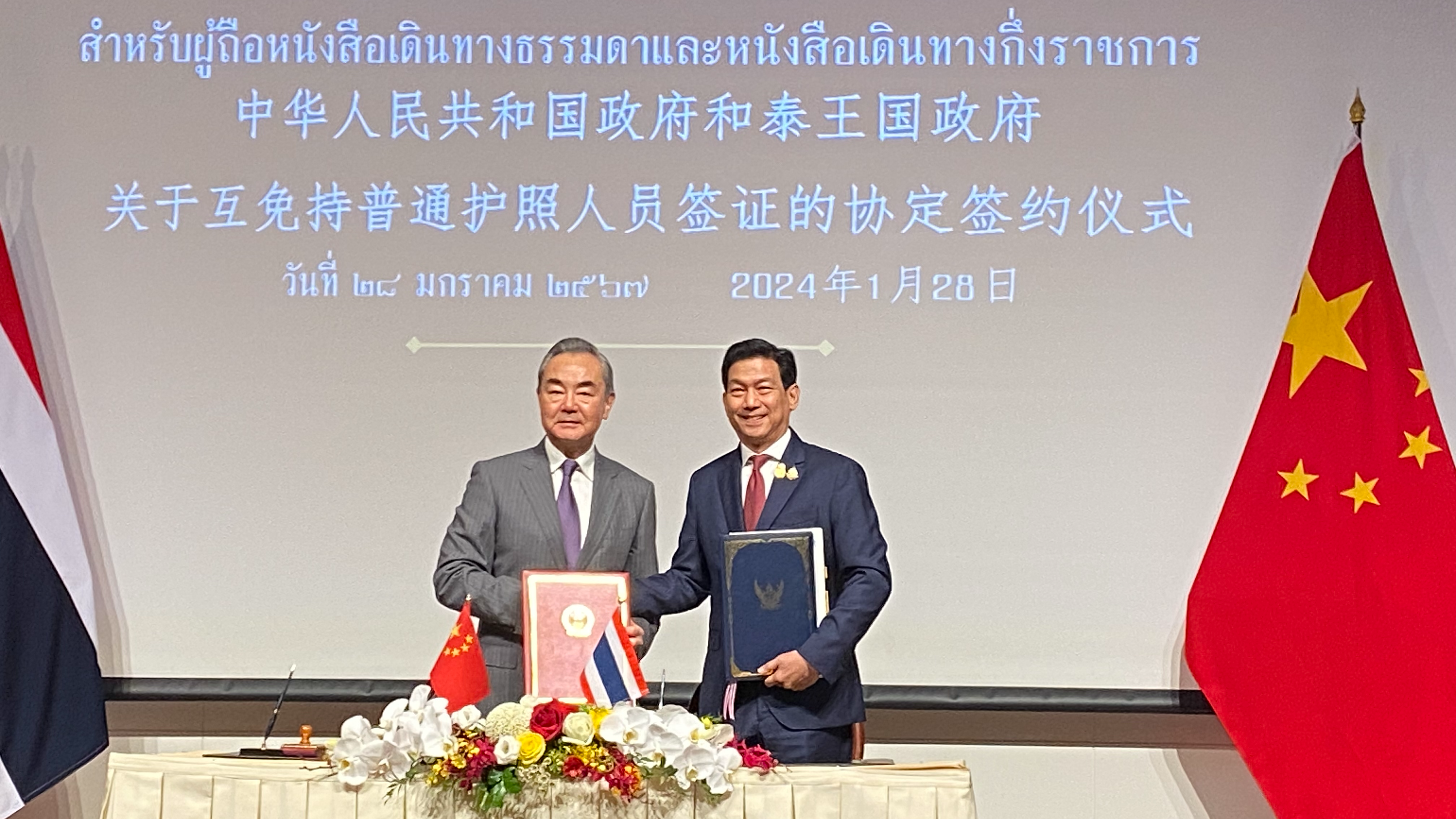 Ο Κινέζος υπουργός Εξωτερικών Γουάνγκ Γι (αριστερά) και ο Ταϊλανδός ομόλογός του Παρνπρί Μπαχίντα-Νουκάρα σε τελετή υπογραφής μιας συμφωνίας αμοιβαίας απαλλαγής από την υποχρέωση θεώρησης μεταξύ Κίνας και Ταϊλάνδης στην Μπανγκόκ, Ταϊλάνδη, 28 Ιανουαρίου 2024. /CGTN