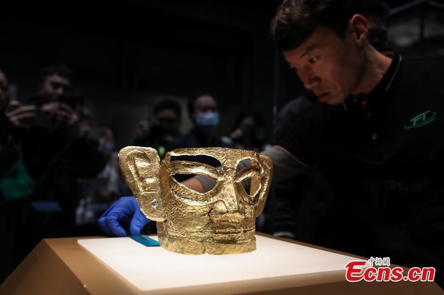 Ειδικός τακτοποιεί μια χρυσή μάσκα, που ανακαλύφθηκε στο σπήλαιο θυσιών Αριθμός 3 των ερειπίων Σανσινγκντούι, στο ανατολικό τμήμα του Μουσείου της Σαγκάης, 29 Ιανουαρίου 2024. (Φωτογραφία: China News Service/Zhang Hengwei)