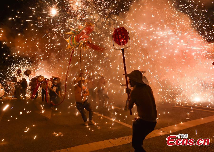 Άνθρωποι εκτελούν τον χορό του δράκου ανάμεσα σε πυροτεχνήματα για να γιορτάσουν την κινεζική Πρωτοχρονιά στην πόλη Μενγκσί, της αυτόνομης κομητείας Σονγκτάο Μιάο κοντά στην πόλη Τόνγκρεν, της επαρχίας Γκουιτζόου της νοτιοδυτικής Κίνας, στις 18 Φεβρουαρίου 2024.  (Φωτογραφία: China News Service/Xie Huifang)