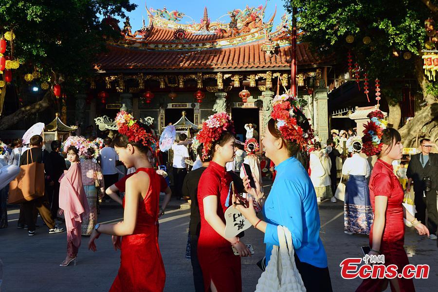 Επισκέπτες που φορούν ανθοφόρα καλύμματα στο χωριό Σουνπού του Τσουεντζόου, στην επαρχία Φουτζιέν της ανατολικής Κίνας, 21 Φεβρουαρίου 2024. (Φωτογραφία: China News Service/Zhang Bin)