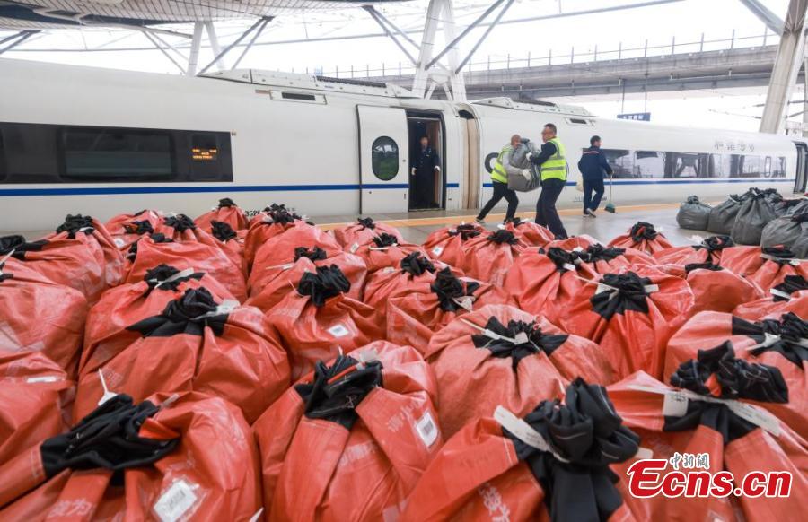 Το προσωπικό της China Railway φορτώνει σάκους με δέματα, τα περισσότερα από τα οποία προέρχονται από τις ηλεκτρονικές αγορές της Ημέρας των Singles ή Ανύπαντρων όπως ονομάζεται η 11η Νοεμβρίου, σε ένα τρένο υψηλής ταχύτητας στο Νότιο σιδηροδρομικό σταθμό του Πεκίνου, στις 11 Νοεμβρίου 2024. (Φωτογραφία: China News Service/Jia Tianyong)