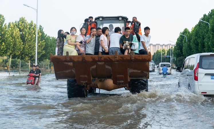 راننده این بیل‌مکانیکی به ساکنان در مناطق سیل زده در هه‌نان، مرکز چین کمک می کند_fororder_2-1