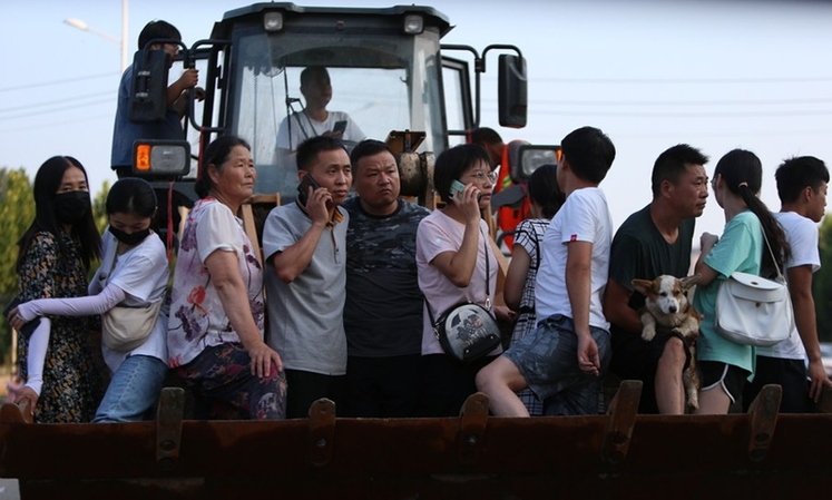 راننده این بیل‌مکانیکی به ساکنان در مناطق سیل زده در هه‌نان، مرکز چین کمک می کند_fororder_2-2