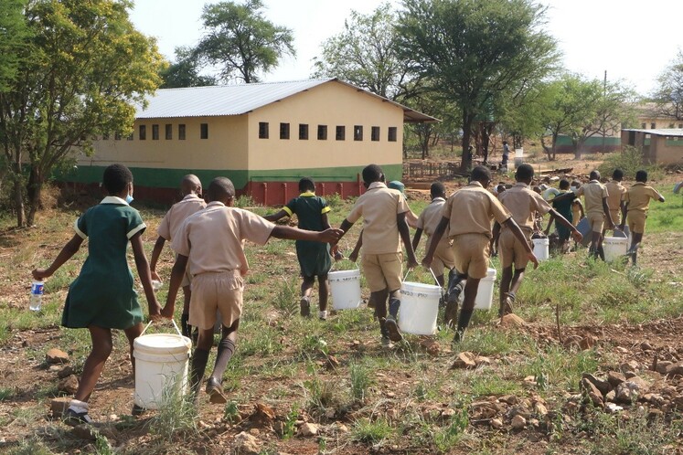 Хятад улс Зимбабвед туслан усан худаг байгуулж өгөв_fororder_塞农多小学学生从水井取水后搬去教室